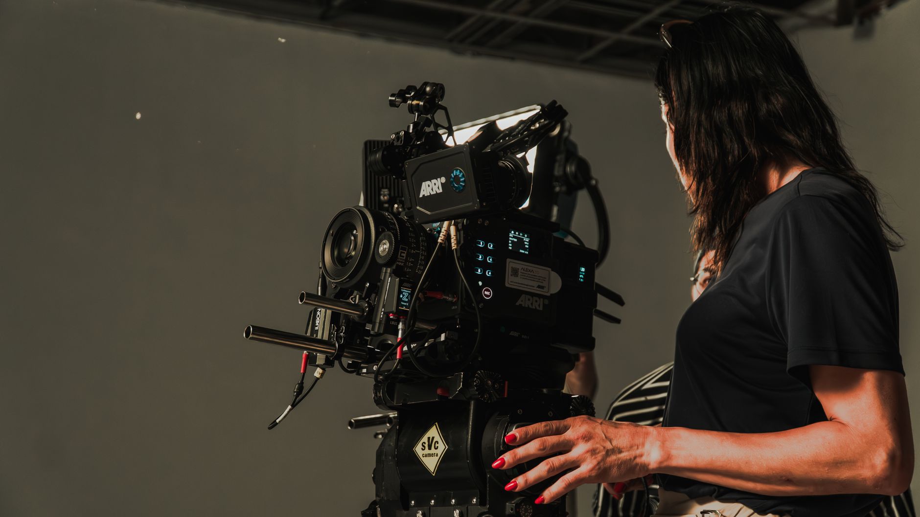 Opencrest chief director checking camera lens in high contrast studio