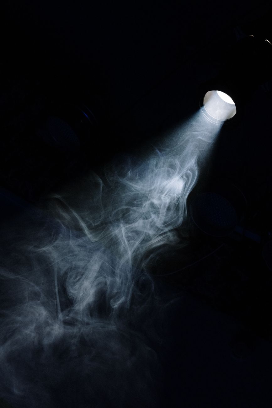 Premium cinematic spotlight beam in pitch black studio